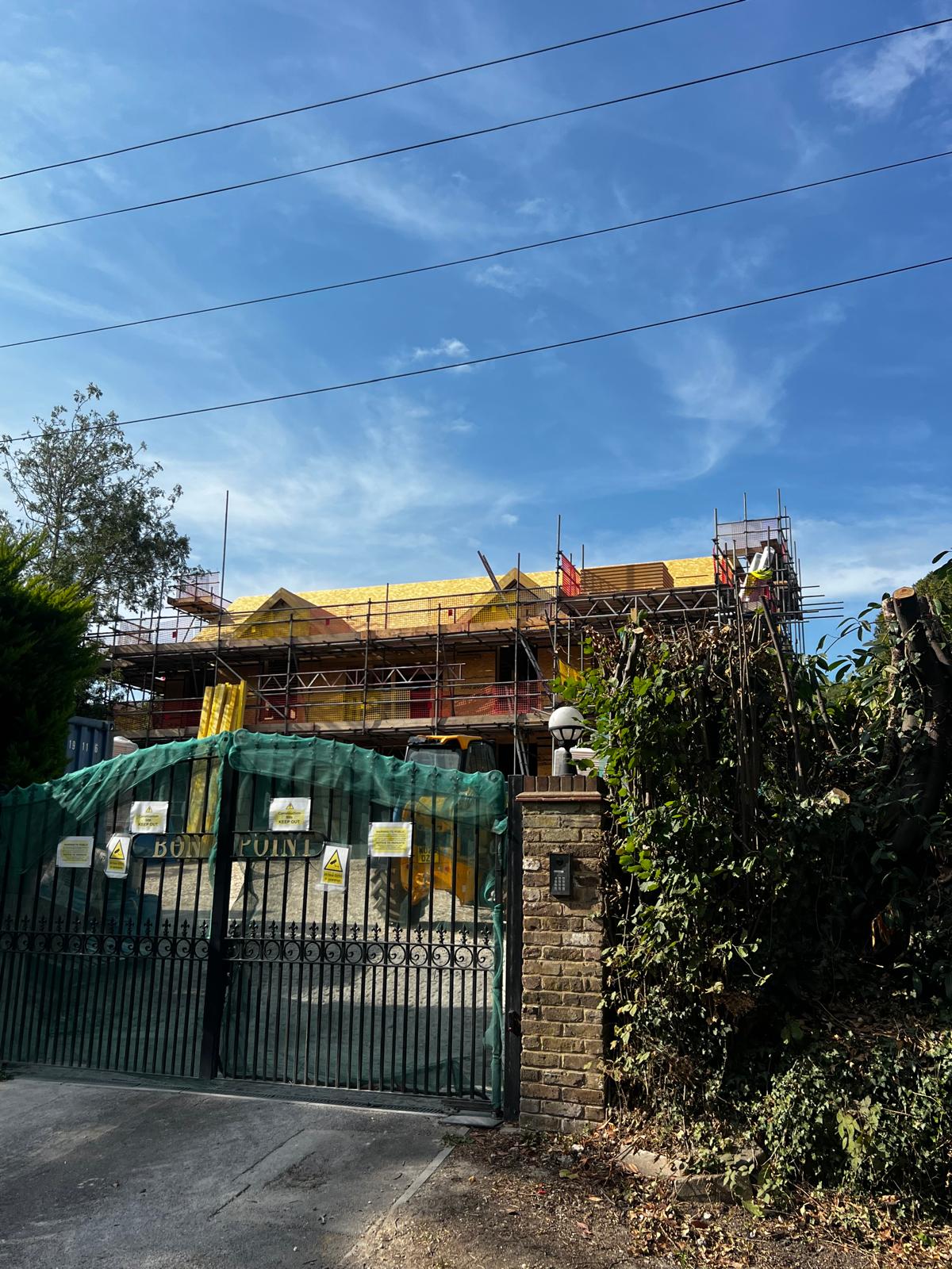 Armstrong Scaffolding new build residential development with full perimeter scaffold, debris netting and roof-level access platform during timber roof construction in South East England