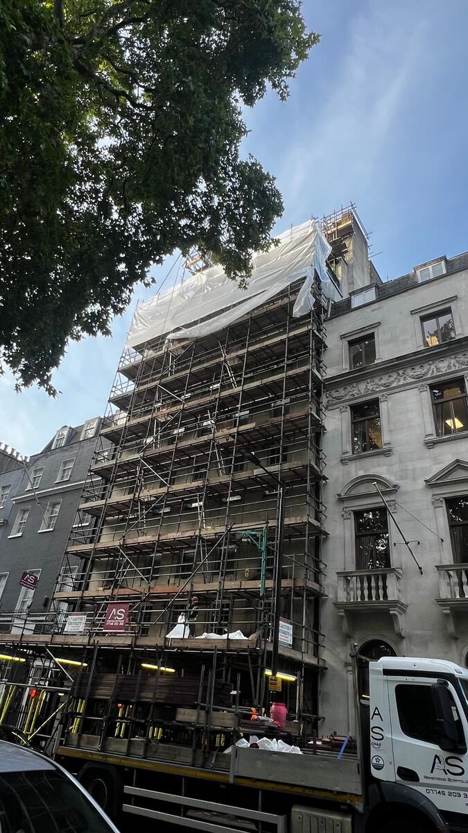 Armstrong Scaffolding designed scaffold part erected on Berkeley Square with the first sheets of shrink wrap going on at roof level and a branded lorry unloading below