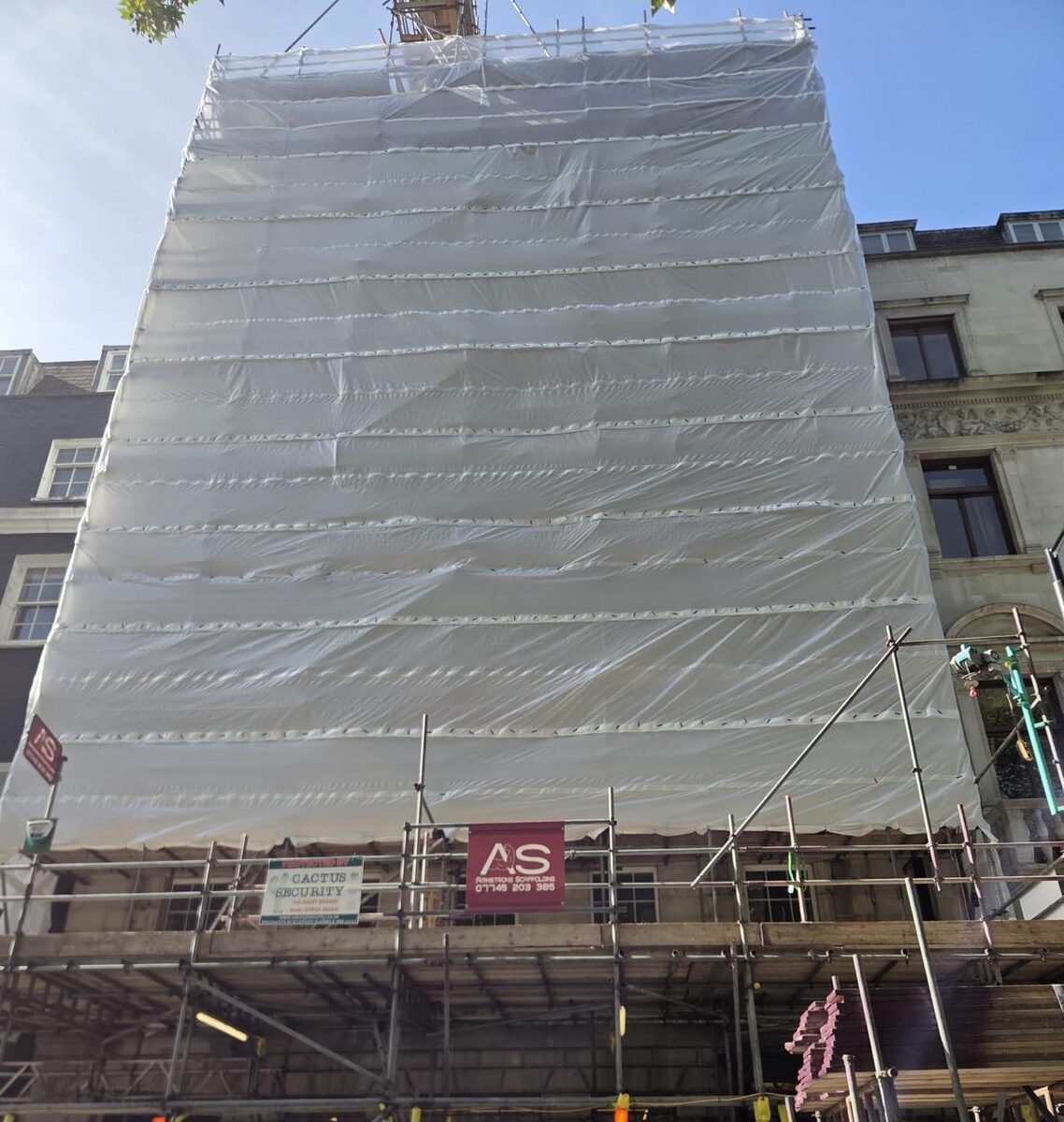 The completed Armstrong Scaffolding structure on Berkeley Square, shrink wrapped across the full elevation from the boarded pedestrian gantry to above the roofline
